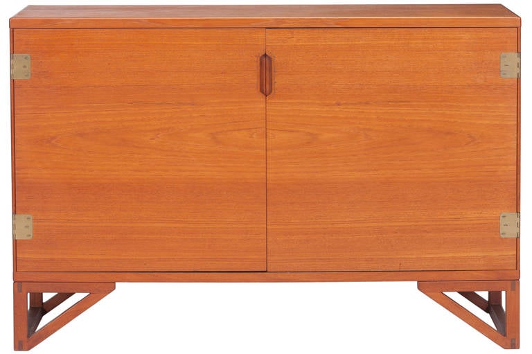 A matching beautiful and finely detailed pair of teak cabinets designed by Svend Langekilde. One cabinet with four drawers and a second removable trays and shelves and brass hinges. Designed by Svend Langekilde. A handsome pair of chests. Signed