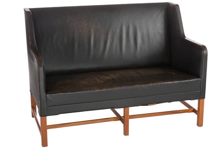 Beautiful and early Kaare Klint settee in original black leather. Settee with beautifully patinated leather and oak legs. An early and handsome example of Danish design.