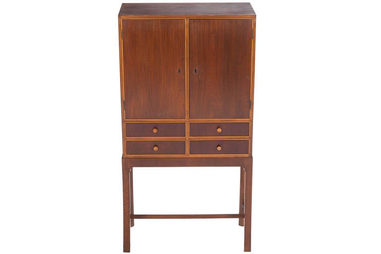 Elegant and well proportioned Danish cabinet with two doors and four drawers in teak with a birch trim throughout. Cabinet with adjustable shelves and original key.