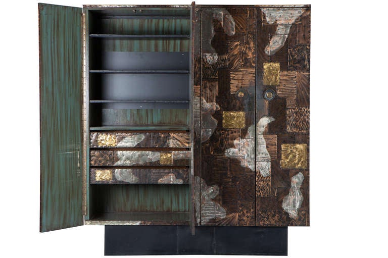 Extremely rare and monumental Paul Evans patchwork cabinet. The expansive surface of this cabinet has a pronounced painterly quality invoking abstract expressionism. Cabinet with 4 doors, forged handles on a black steel base. Interior with 7
