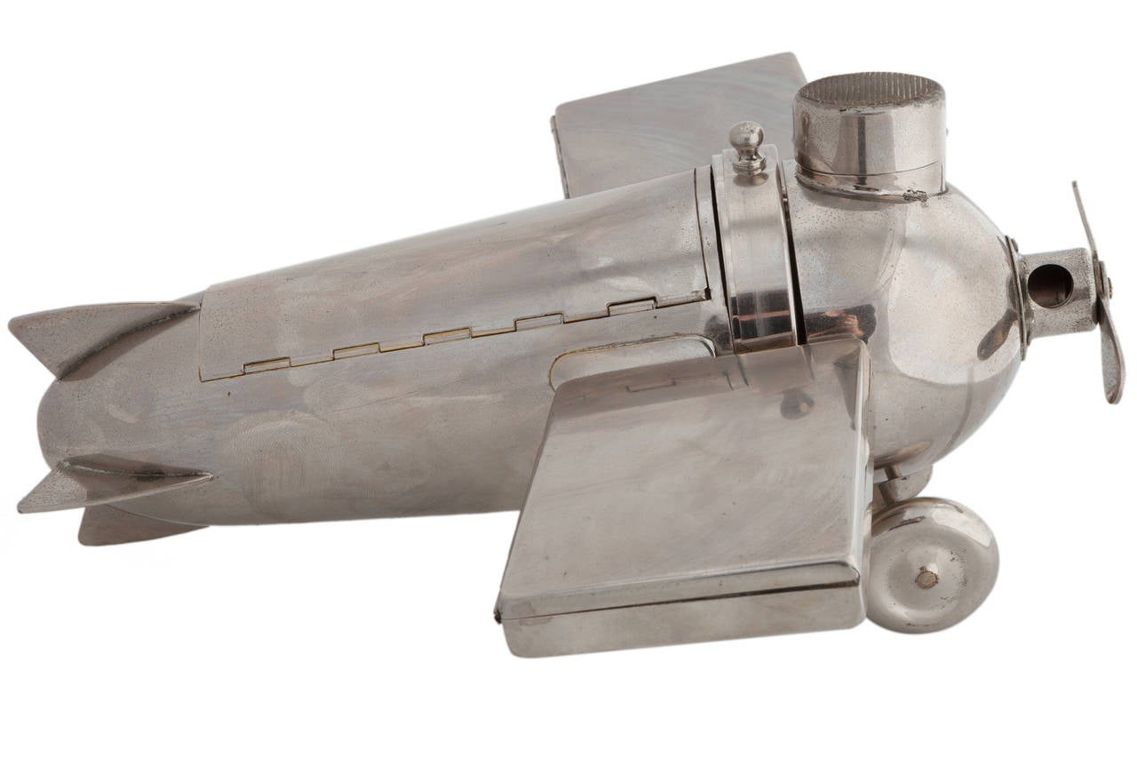 A very rare Art Deco 'smoker’s companion,' in the form of a stylized aero plane, manufactured in Germany by J.A. Henckels in the late 1920s. Facilities afforded the smoker include a cigar box in the fuselage, a pair of removable cigarette cases in