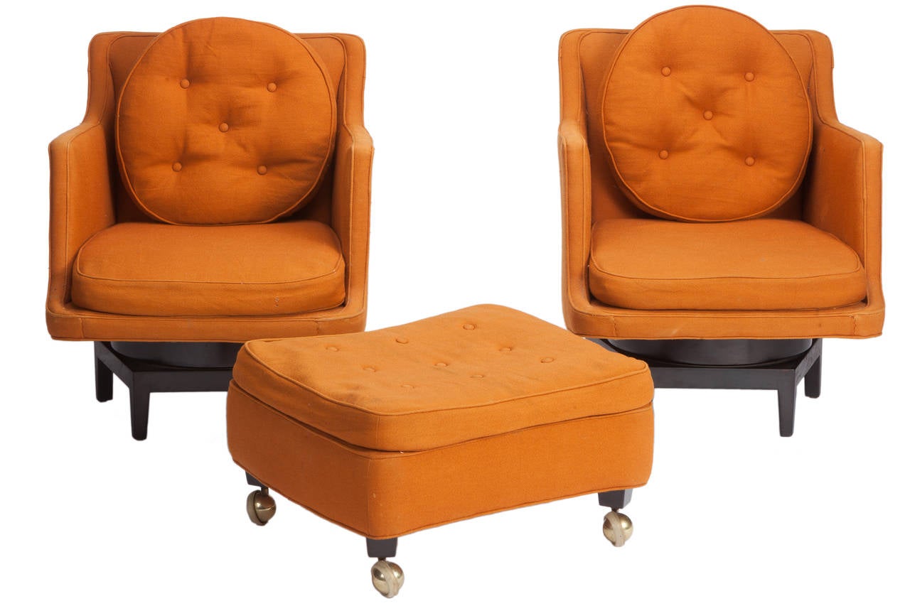Pair swivel lounge chairs and rarely seen ottoman designed by Edward Wormley for Dunbar. Model #5609. Mahogany bases with original upholstery. Original fabric is worn and is in need of replacement. Ottoman measures 20 x 24 x 14.
