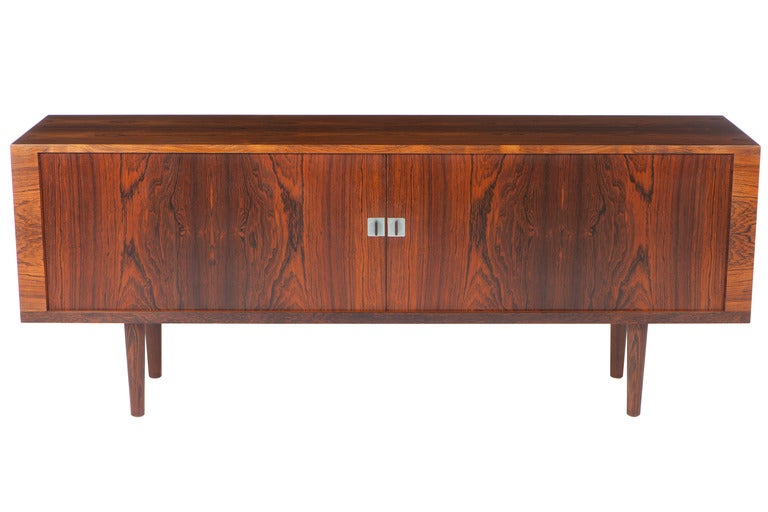 A very fine rosewood credenza/cabinet/sideboard designed by Hans Wegner and manufactured by RY Mobler. With two sliding tambour doors, enclosing a soaped oak interior with four shelves, with four adjustable trays on solid rosewood legs.