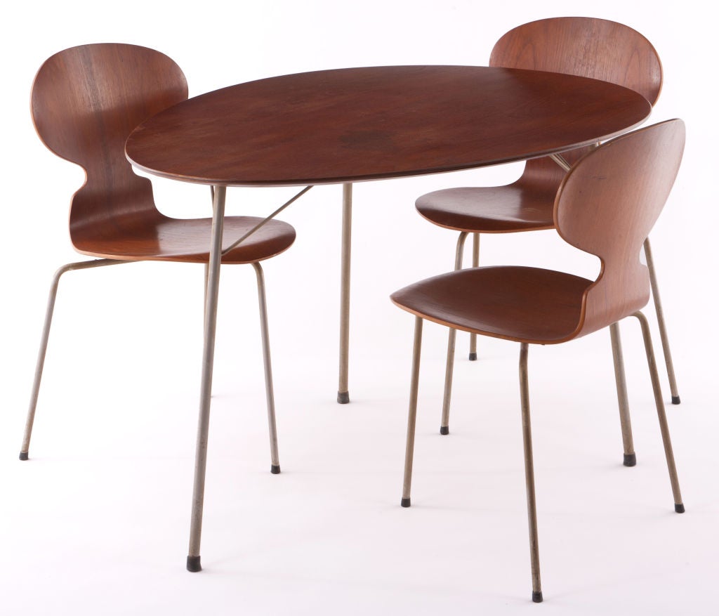 Manufactured by Fritz Hansen and Designed by Arne Jacobsen. Egg shaped table and 3 three legged ant chairs.