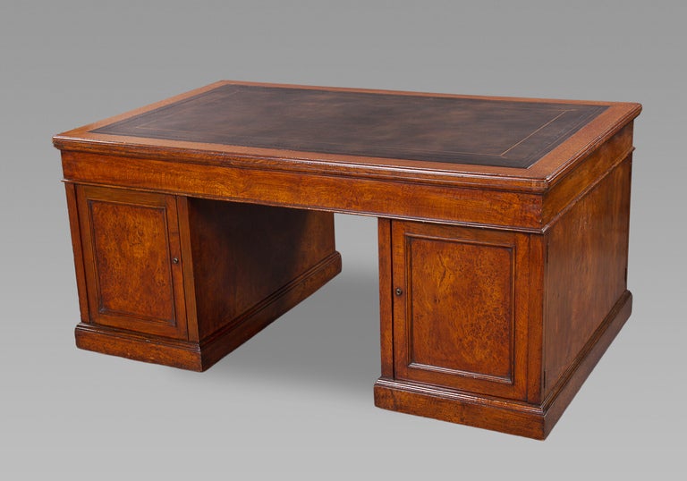 By one of the nineteenth century's leading cabinet makers, Holland and Sons, this desk is of highly figured burr golden oak, with an excellent quality gilt-tooled black leather inset top above a frieze with three drawers supported on two pedestals,
