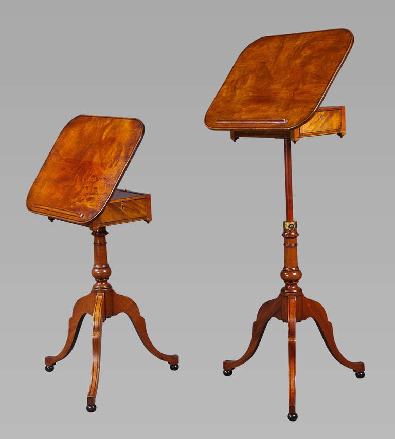 A good pair of George III mahogany side tables with ebony stringing convertible to reading tables, on telescoping pedestal supports. The tops adjustable with brass fittings above single drawers, the telescoping baluster columns over tripod hipped