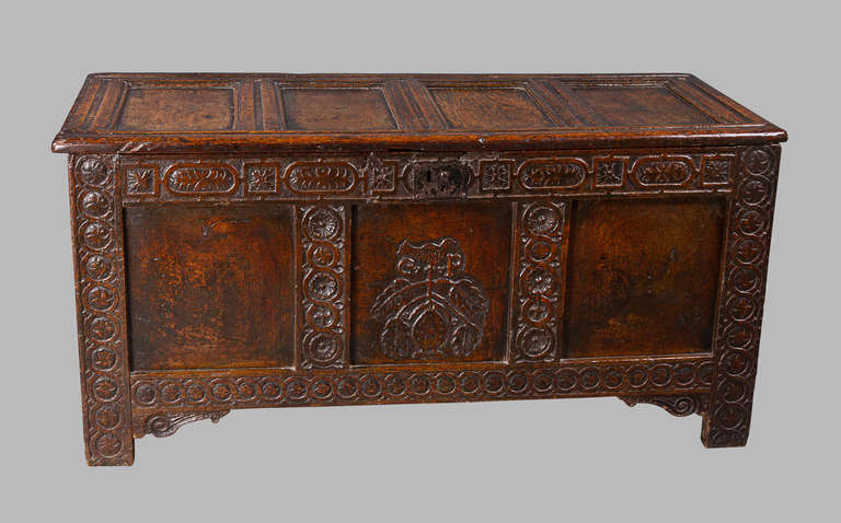 A very interesting and early oak chest from the Charles 1st period circa 1620. The four panel top with original ring hinges above a three panel base, the panels surrounded by foliate and rosette carved stiles and crossbars. The interior with a