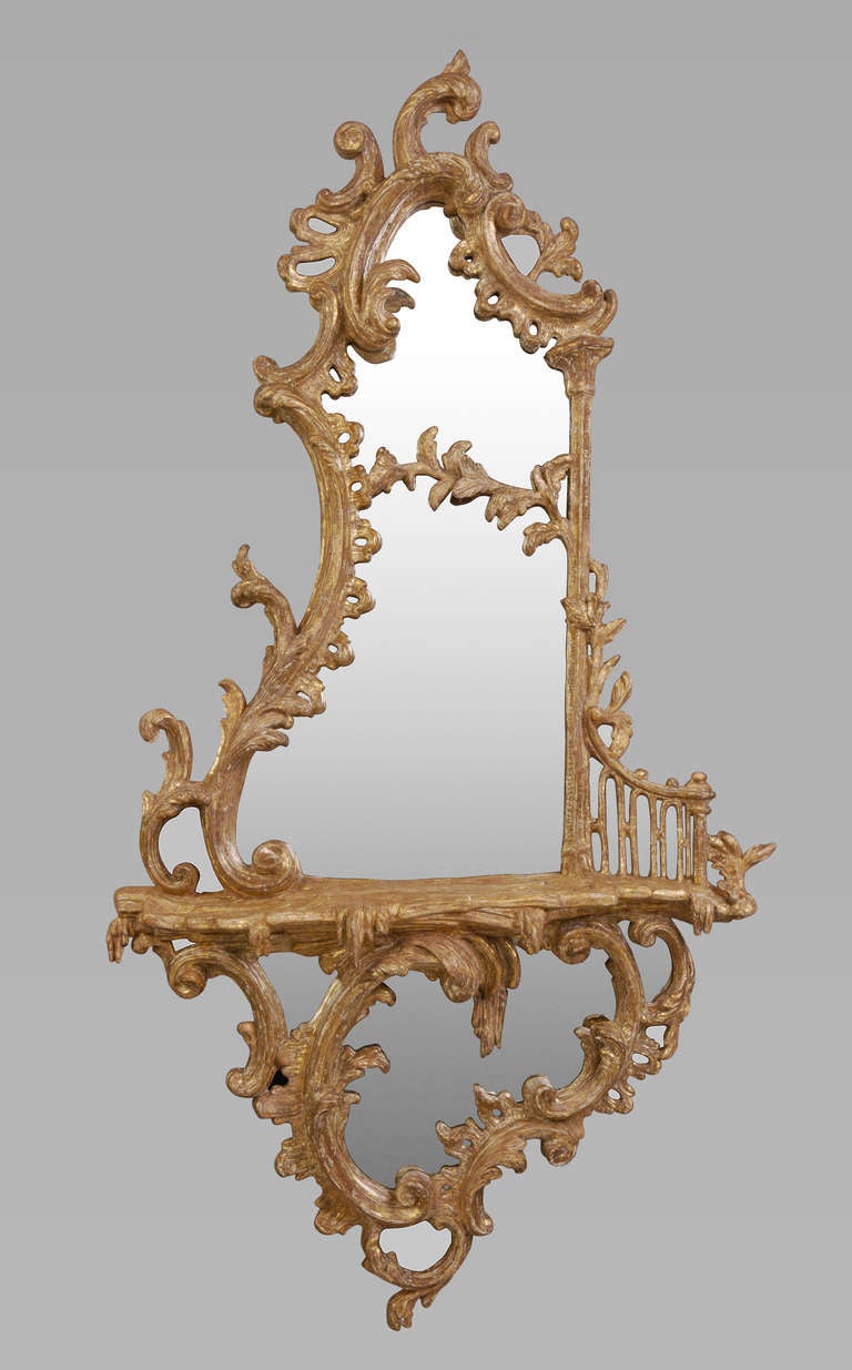 A fine mid 18th century girandole with later replaced mirror plates and retaining its original gilding that has been dry stripped. The plates with divided asymmetric cartouche frames with a profusion of c-scrolls, foliate branches, columns and