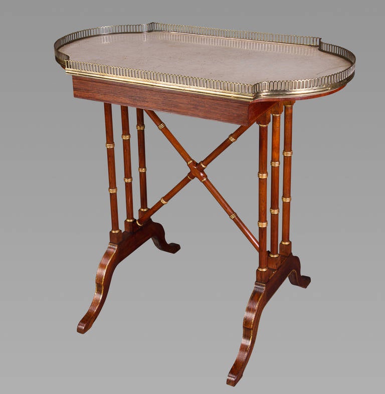 The shaped rectangular white marble-top with a pierced brass gallery, the ends each with triple ring-turned supports joined by conforming vertical X-shaped stretchers, on four splayed legs, the underside of the marble top bearing the pencil