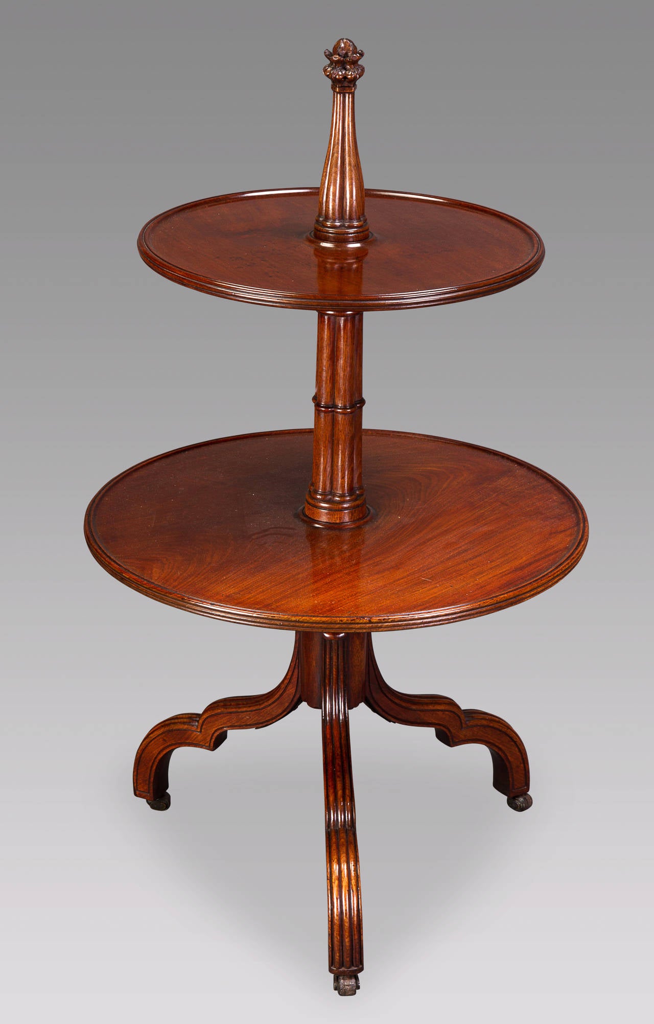 Of excellent quality timber, the column with finely defined cluster of columns bound by lobed collars and topped with a well carved Gothic crocket, the two revolving tiers reeded to the edges, the shaped & reeded tripod legs terminating in the