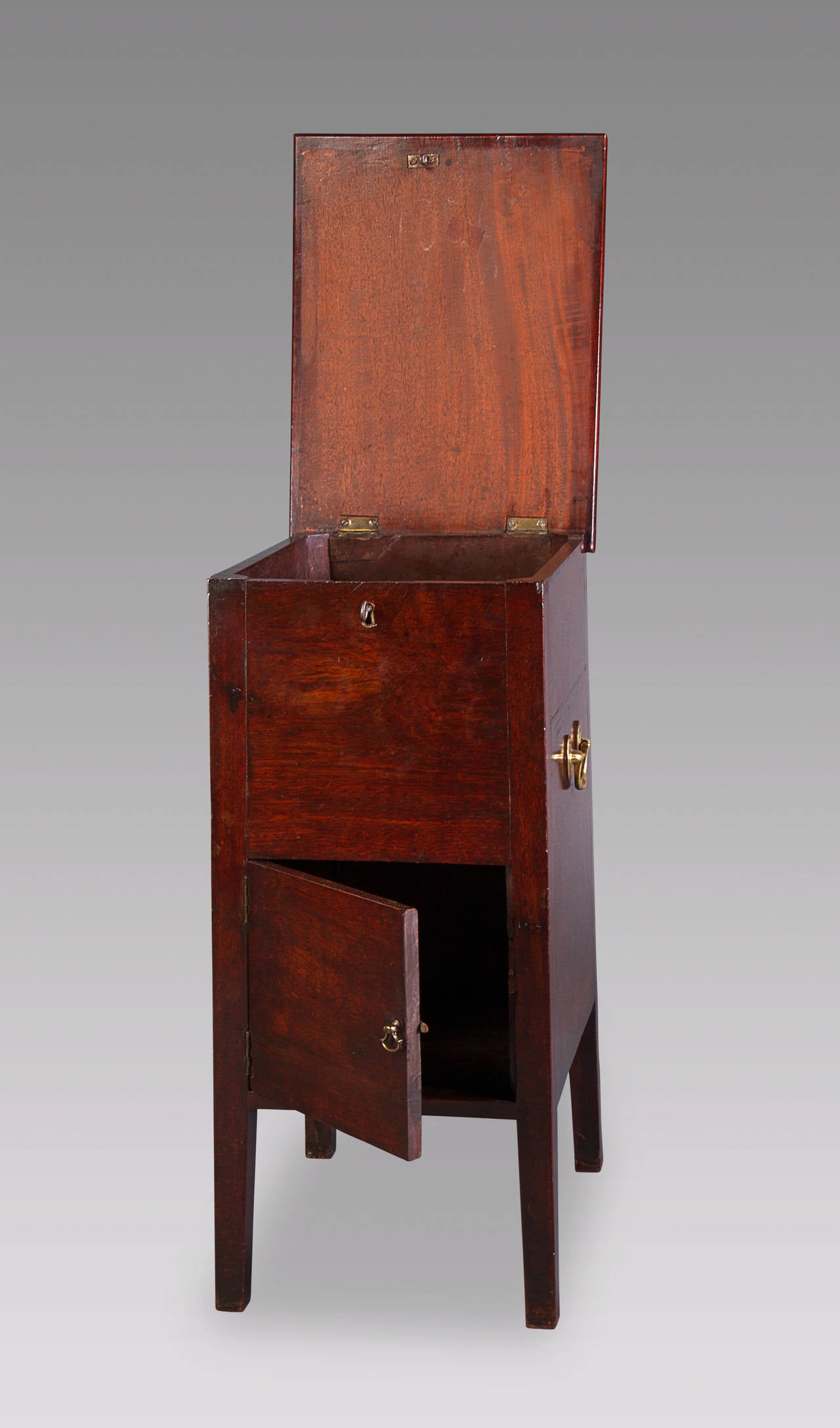 A very good mahogany cupboard from a very early period with great color and patina. This piece retains its original brass hardware and lock, and comes in a rare slightly tapered design. Its early origins are evident in the fact that the top lifts up