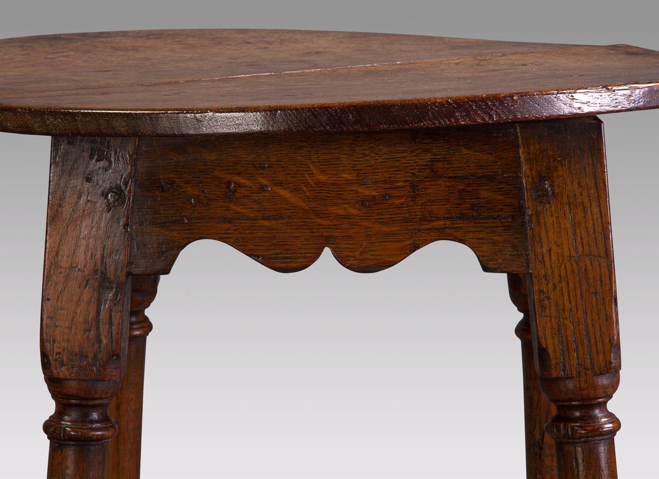 A delightful table of magnificent color in untouched condition. The circular top has the unusual feature of being affixed to the frame by its original nails rather than being pegged. Over the years, the top to this table has developed the pale gray