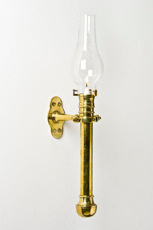 A rare and attractive piece. The heavy brass, seamed candlestick is held by a gimbal and attached to the bulkhead of a ship to ensure that it remains vertical in heavy seas. The stick has an internal spring to ensure that the candle is always pushed