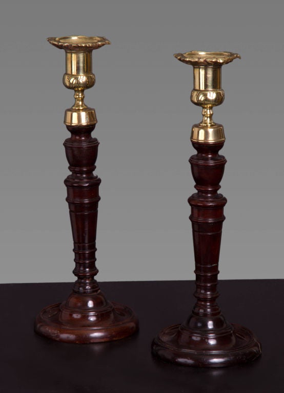 A fine pair of candlesticks with turned mahogany stems, cast brass nozzles and turned lead weighted bases. With a Provenance to Norman Adams Ltd, September, 1977 and in a private collection, Washington D.C.