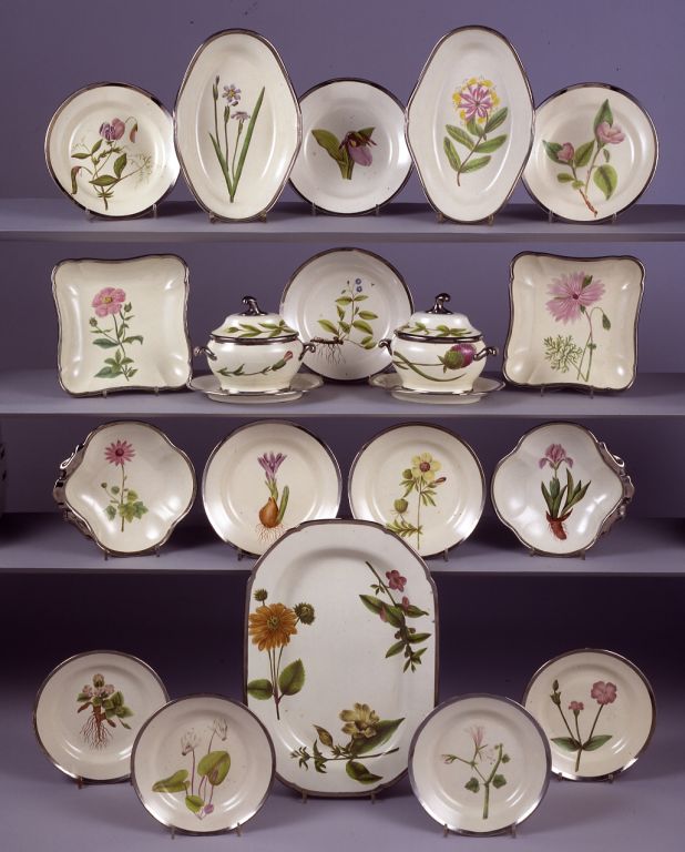 An English Pearlware Botanical Dessert Service, comprising a pair of oval sauce tureens, covers and stands, a 16½-inch chamfered rectangular platter, a pair of oval dishes, a pair of square dishes, a pair of shell-shaped dishes and ten plates;  each