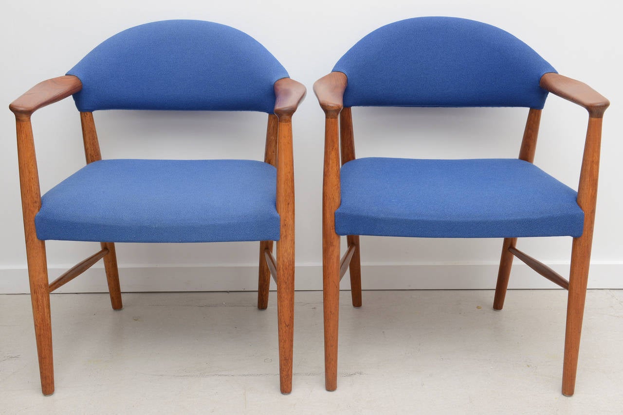 Pair of armchair, Danish Mid-Century Modern, circa 1960s. These simple and elegant arm chairs are a wonderful example of the Danish Mid-Century Modern period. They are made of oak with teak armrests. The seat and back are upholstered in the original