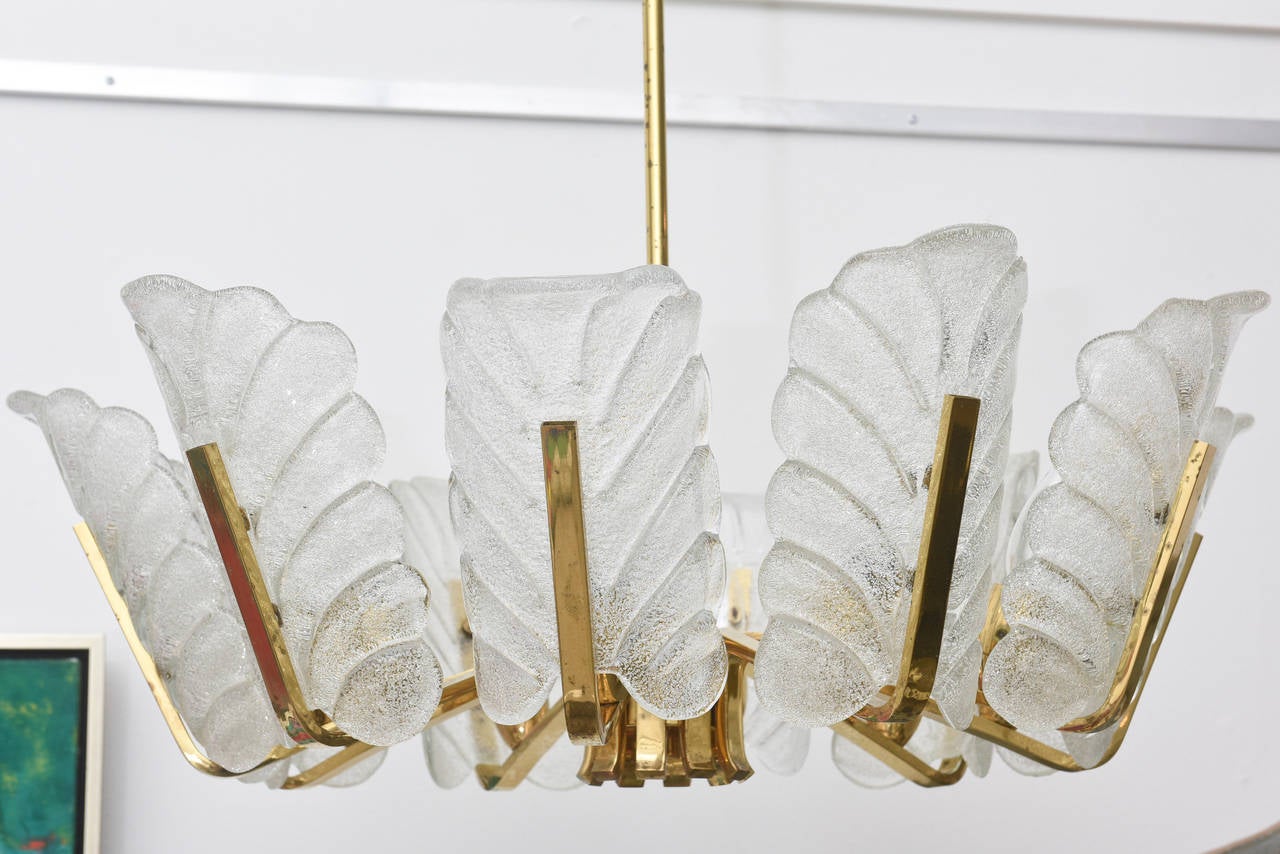 Vintage 1960s pendant chandelier with glass shades and brass fittings by Carl Fagerlund for Orrefors, Sweden. Beautifully carved clear glass shades in a leaf design on brass fittings. Chandelier is unusually large with 10 arms.
Fixture has been