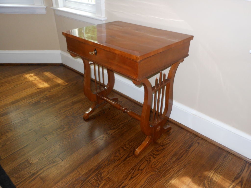 A beautiful Austrian Biedermeier sewing table with lyre on each side in Cherry wood with Ebony keyhole.
The top opens and contains various compartments.