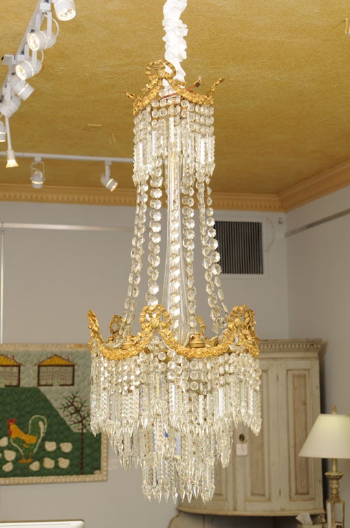 19th century antique French cut-glass crystal and bronze chandelier with three levels of 9 interior lights. Outstanding gilded bronze floral carvings. It has been electrified to US.