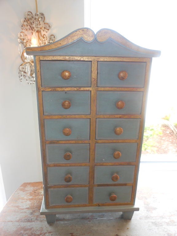 Beautiful rare 20th Century Swedish miniature chest with twelve drawers in a typical Gustavian blue colour with gilded borders and knobs, coral red inside the drawers.