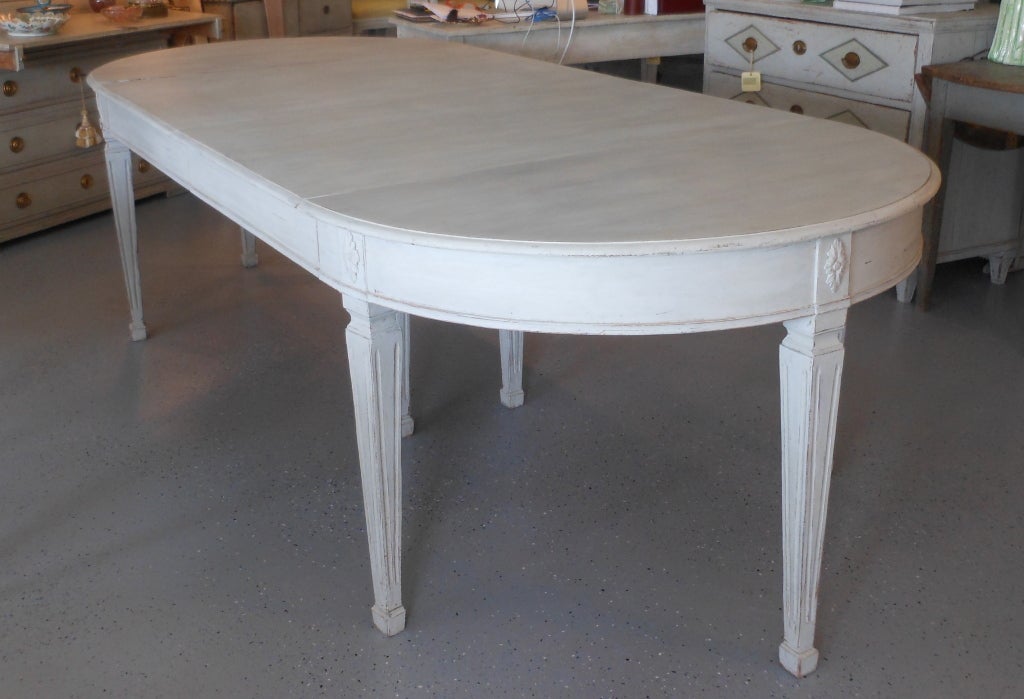 Beautiful light grayish white antique round dining table ; which can be oval when extended with one, two leaves. 
Very sturdy with two legs in the middle.
