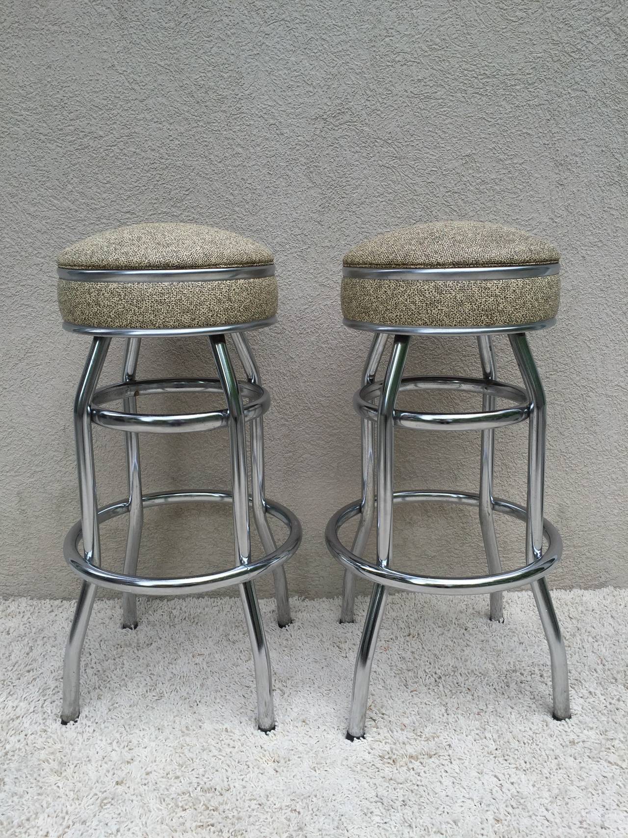 Pair of Art Deco swivel bar stools, with all original black and off white naugahyde, in all original condition.