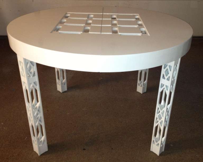 White lacquer round opens to oval dining table with glass insets,
and pierced legs and alligator finish, closed 44'' round with two leaves 18'' each opens to 80'' x 44 x 29.50'' high.