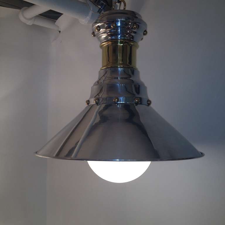 Circa 1940's polished aluminum and brass bell shaped hanging chandelier fixture with white glass shade