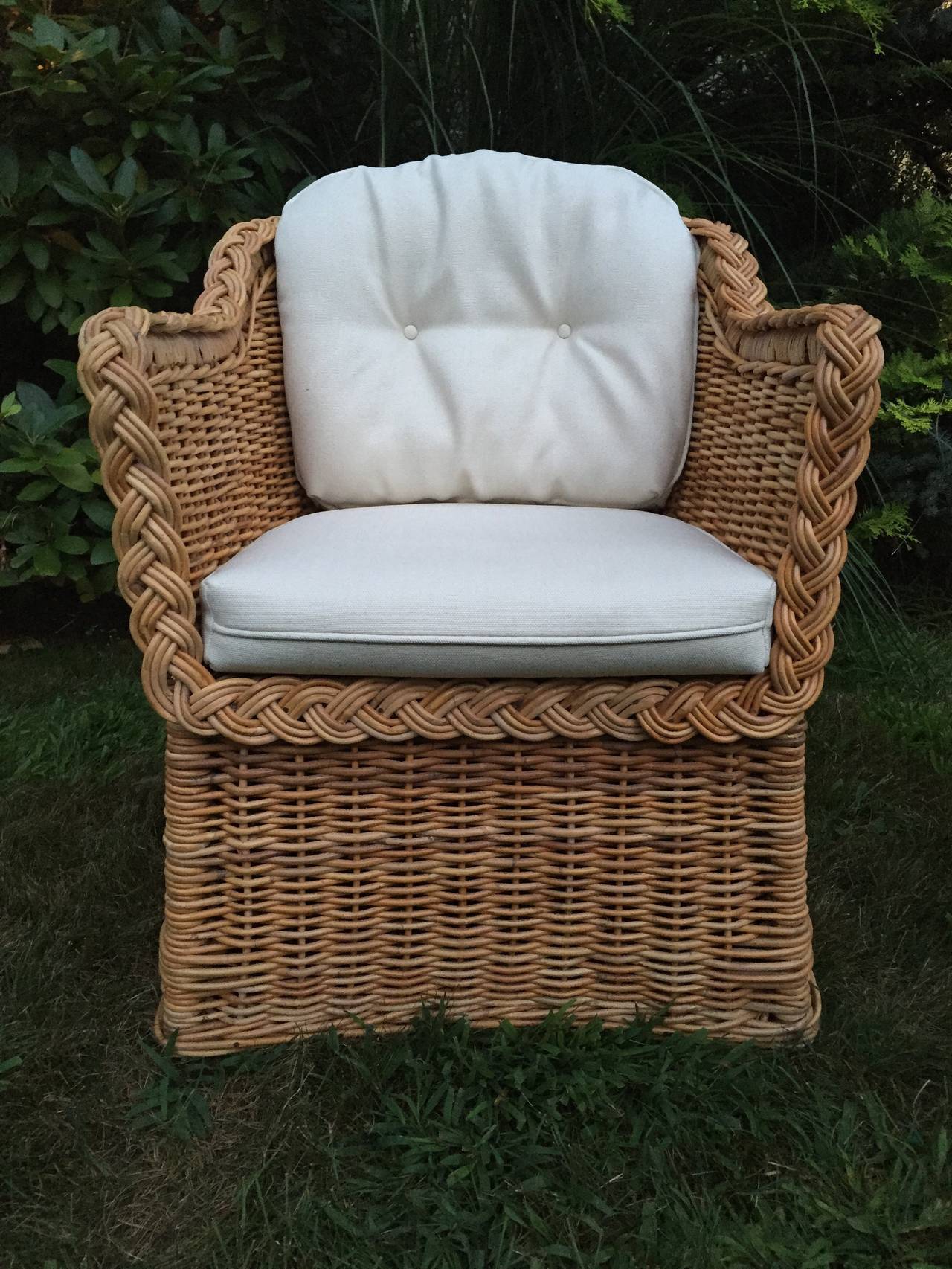 Pair of Michael Taylor wicker/rattan weaved armchairs, with two loose off-white weaved cushions wit button tufts. Wonderful Construction and very comfortable.