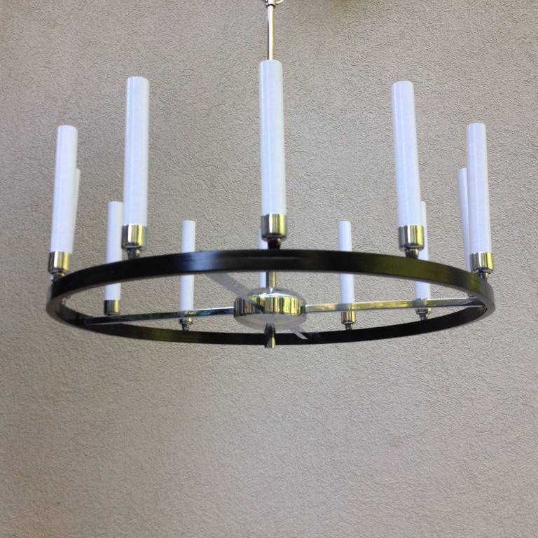 Tommi Parzinger style circular black and polished chrome long 12 candlestick chandelier, cross bar, with central chrome disk and finial.

The size of chandelier varies to hang drop from 21.50 to 30