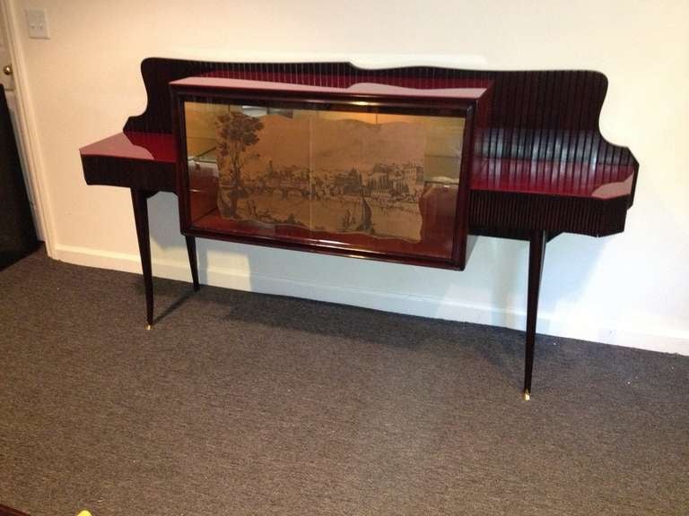 Osvaldo Borsani Italian (1911-1985) unusual mahogany Burgundy red glass and decorative front Lighted mirrored interior, two hidden draws sideboard.