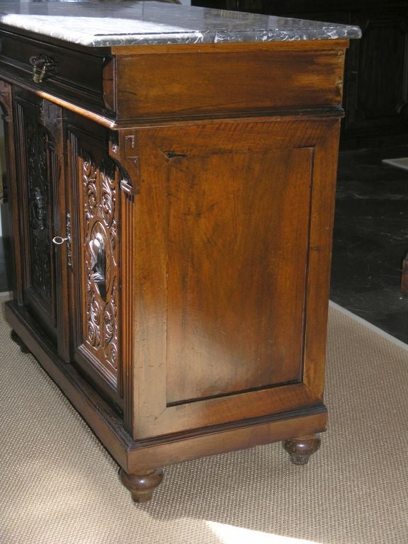 Rectangular marble top with molded edge over a long drawer above two carved doors.