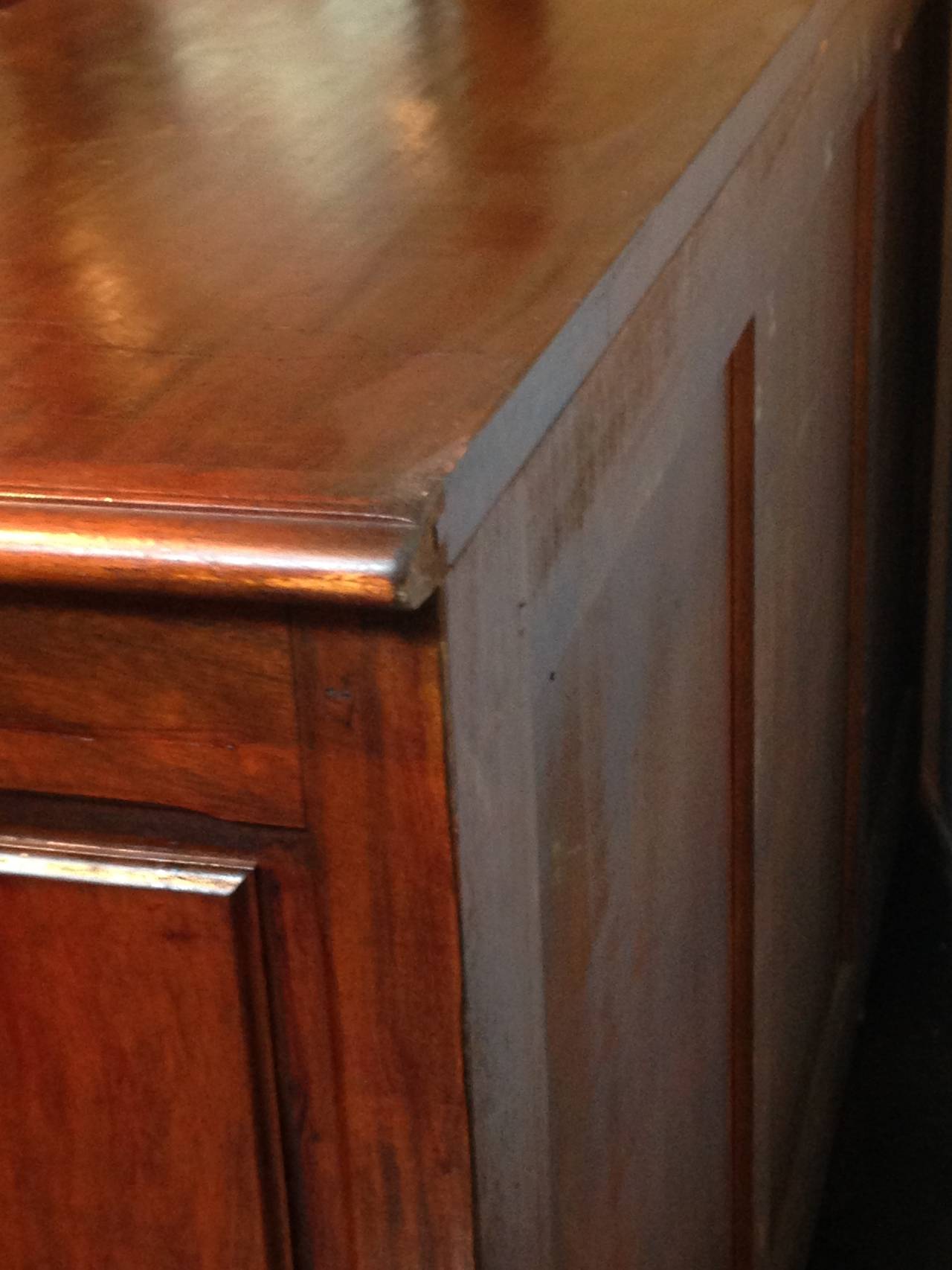 Rectangular top with molded edge over three drawers above three paneled doors.