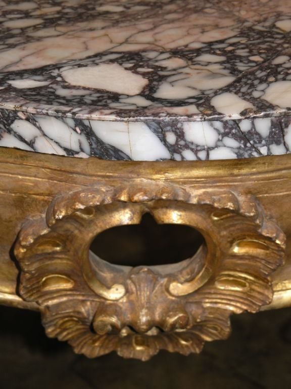 Southern Italian Rococo giltwood console tables. Each rare Roman Breccia di Sciro marble top of serpentine outline. Above a conforming foliate and scroll 24-karat giltwood base centred by a pierced cartouche raised on channel moulded cabriolet legs.