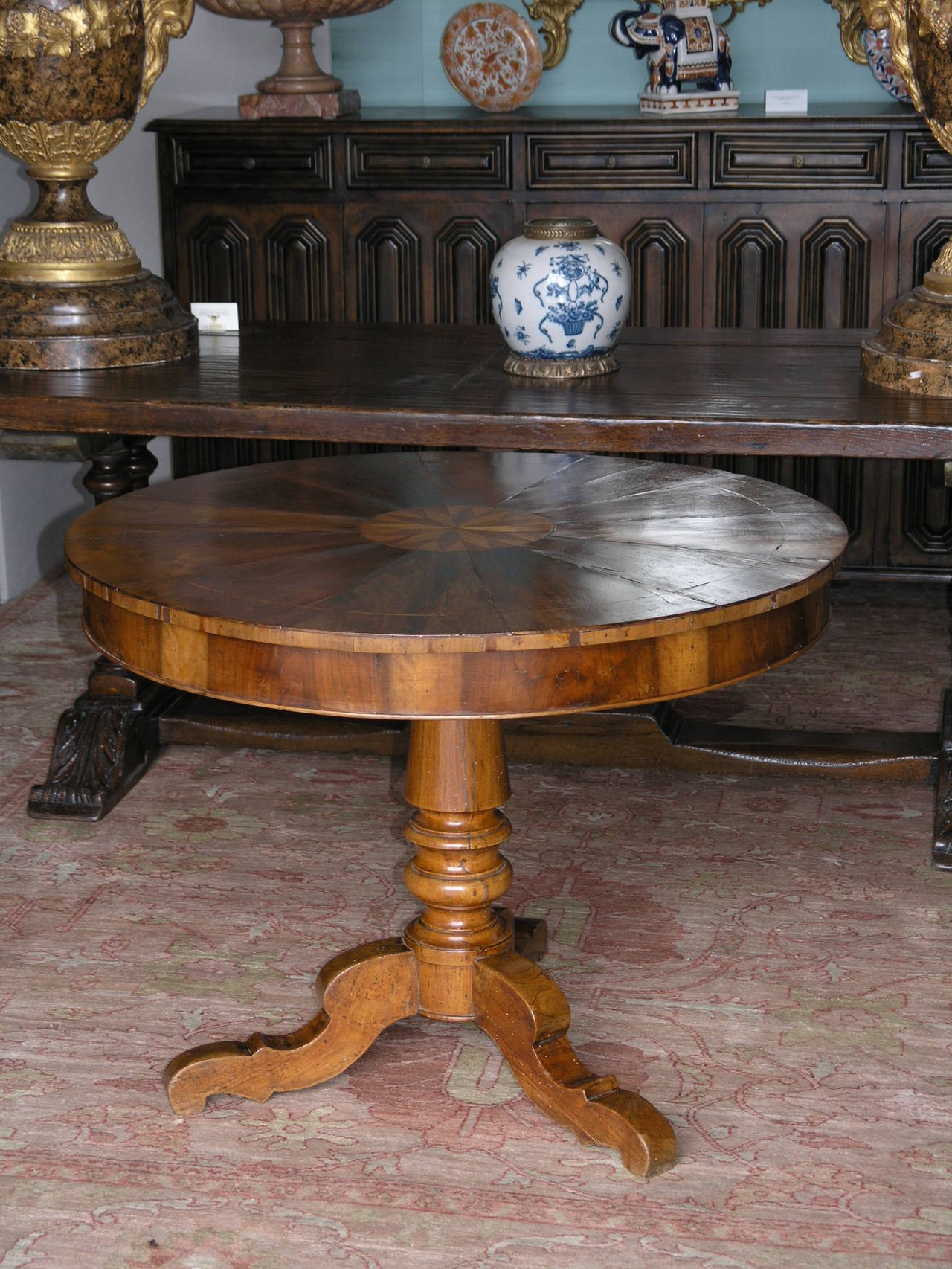 Circular inlaid walnut top raised on a turned columnar support , the tripartite base with slightly under scrolled feet