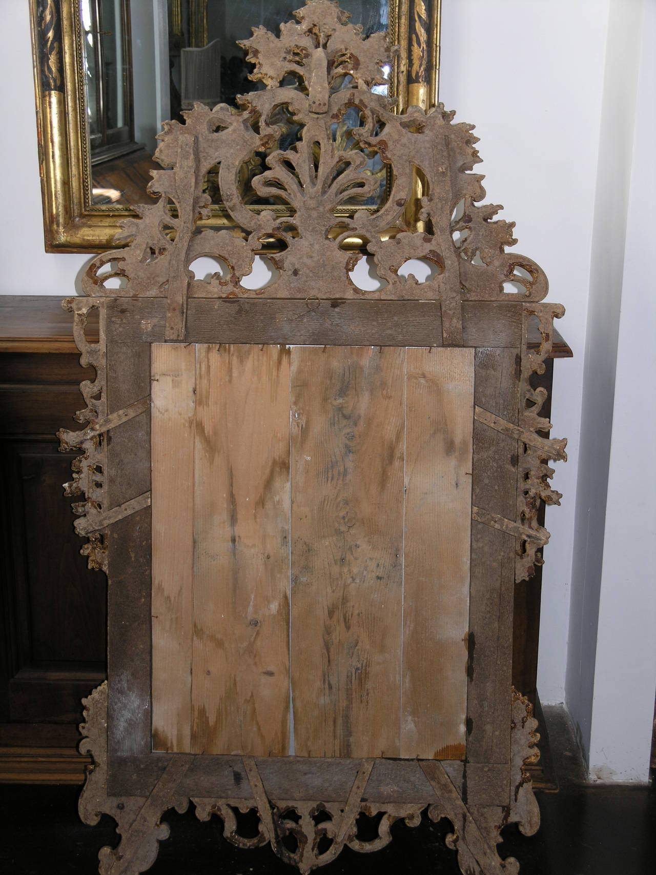 The rectangular plate within carved giltwood frame surmounted by a bold pierced foliate C-scroll cresting leading to similar pendants, on C-scroll outswept feet centered by a leafy apron.