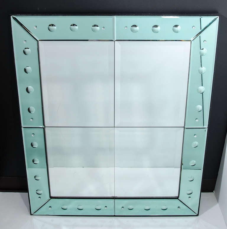 Rare and exceptional Art Deco mirror comprised of Venetian green glass mirrored borders with reverse etched convex circle designs. The mirror is all hand beveled with rosette fittings. It has four mirrored center panels creating a quad design with