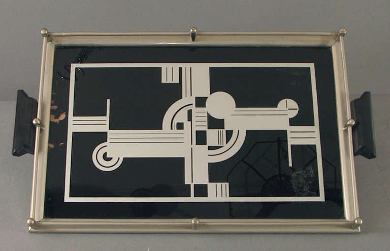 An early (20's) German (marked) reverse-painted glass cocktail tray, featuring a stellar Art Deco design. The handles are made of an early type of plastic.  

Some flaking of the black background paint on the left-hand side, and near the right