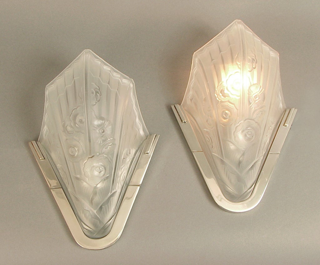 Here's a pair of exceptional Art Deco sconces in super condition.  They have a very spare, economical form, but are beautifully embellished with classic Art Deco motifs, stylized flowers and the obligatory radiating sun rays with geometric