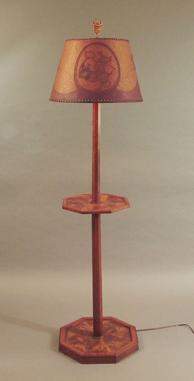 This floor lamp (as furniture!) has excellent proportions and presence, and the deep colors of the rich woods play beautifully with those of the American antique shade (from around the same time as the lamp base).  It's difficult to tell from mere