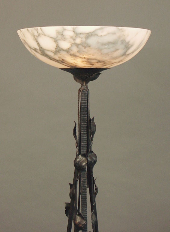 This French wrought iron floor lamp from the 'teens or 'twenties demonstrates the French reverence for Nature, with its multitude of leaves, branches, flowers, and its natural stone shade. 

The (original) alabaster bowl has complex veining