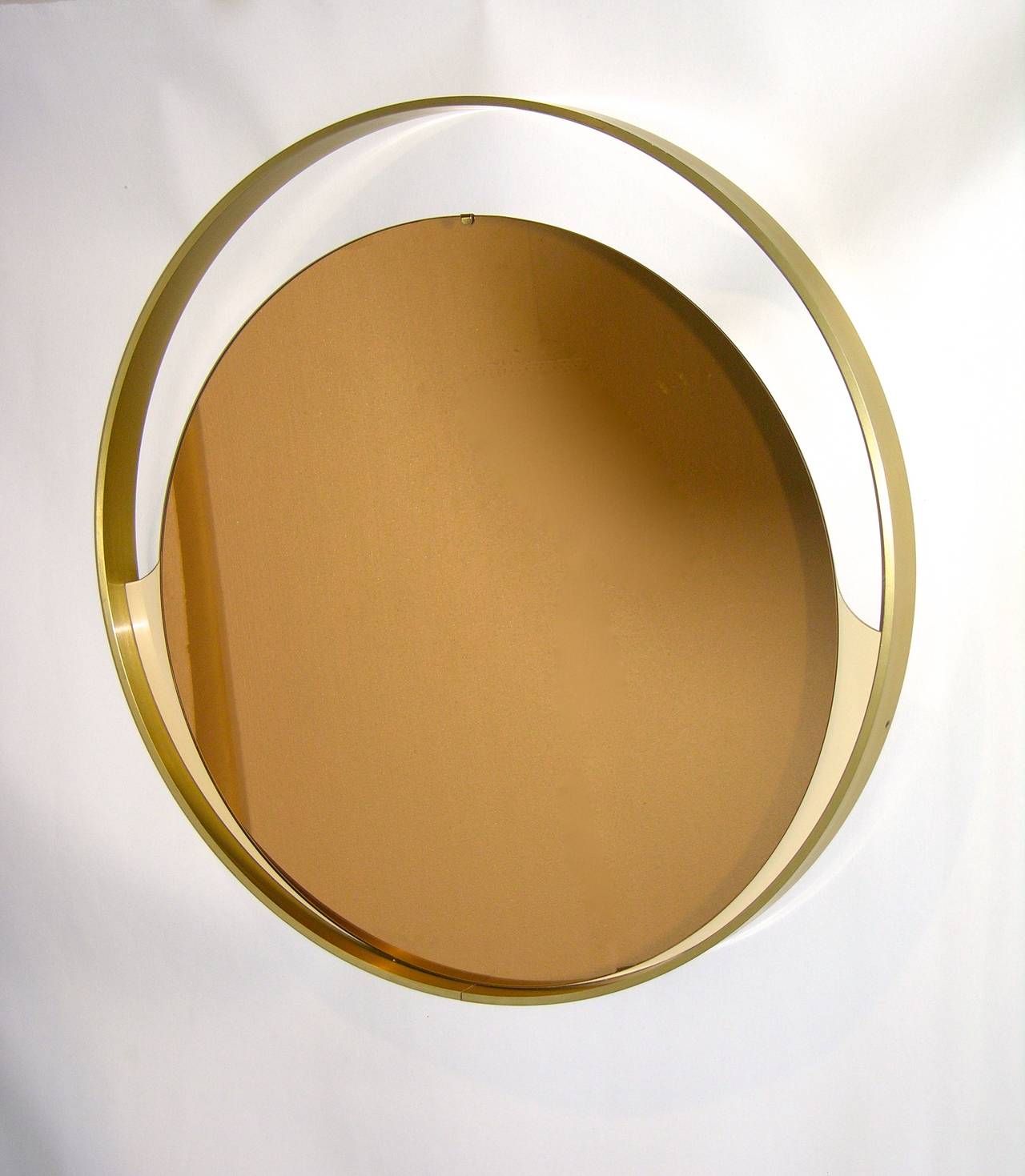 A very rare round mirror by the Italian Company Rimadesio, founded in Desio in 1956. Immediately renowned for innovation in glass techniques, combining architectural accents in the design with style and functionality, the company specializes in