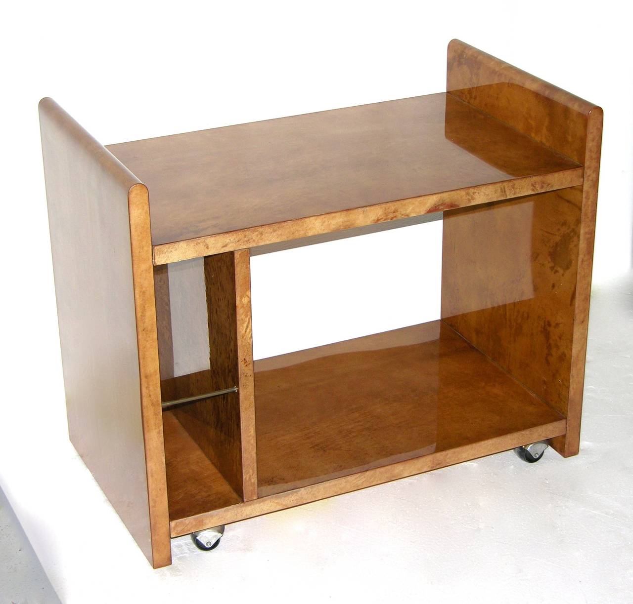 A rare piece by Aldo Tura, excellence in the construction and refinement, the structure in solid maple is elegantly covered in amber goatskin; the shape and wheels provide versatile use: a charming side table with display space, a serving table with