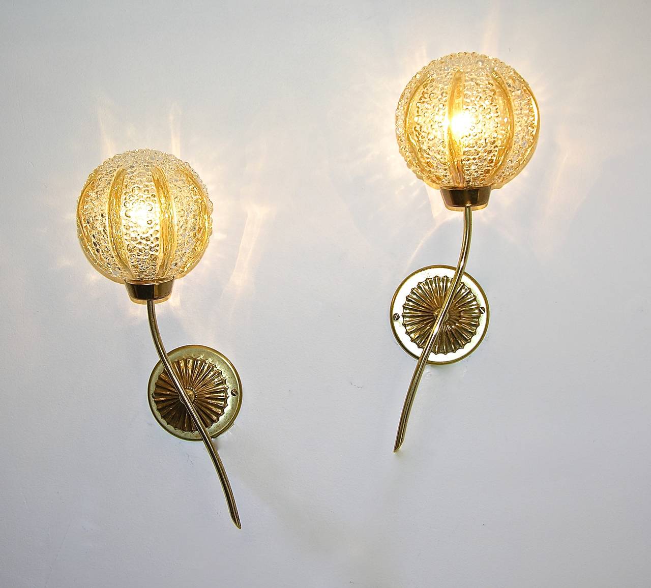 Whimsical pair of wall lights by Barovier, the Murano glass spheres are worked with a texture in relief and decorated with delicately gilded vertical outlines supported by a handmade bronze branch mounted on a round chased plaque.