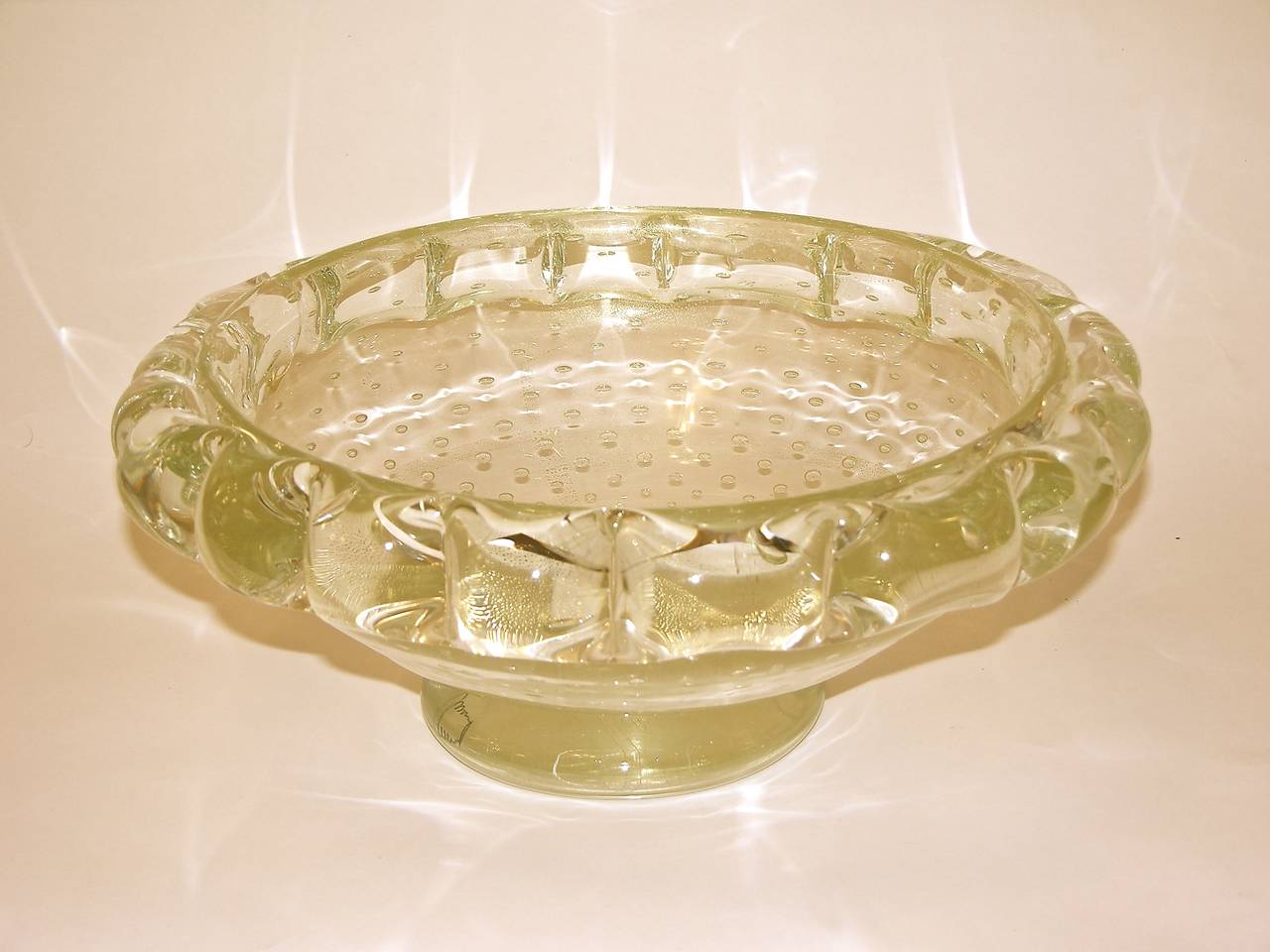 This Murano blown and handcrafted glass bowl is a rare find. It was designed and worked with 24-karat pure gold in the glass in the 1970s by Costantini. This is particularly charming for the unusual hand pinched border and for the bullicante