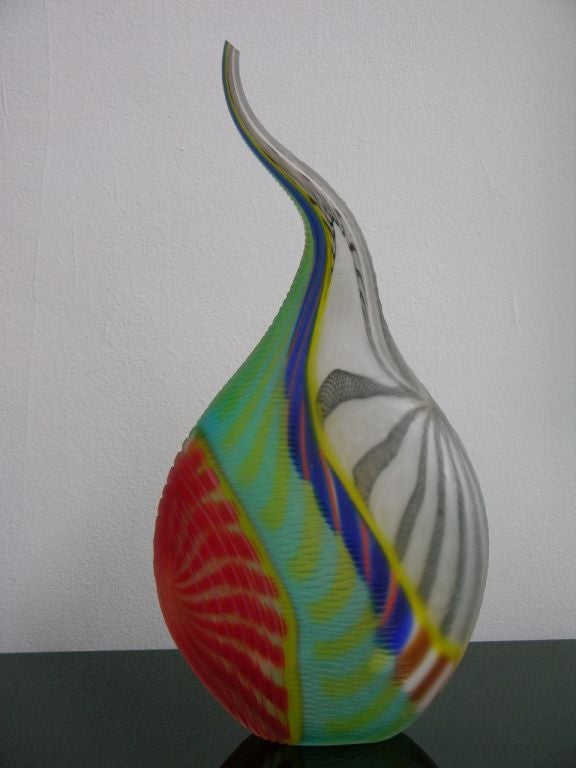 This extraordinary Work of Art in Murano glass by Maestro Tagliapietra is particularly different for the shape with a long neck, that makes the piece very sculptural, and because masterly decorated with several difficult techniques: multiple incalmo