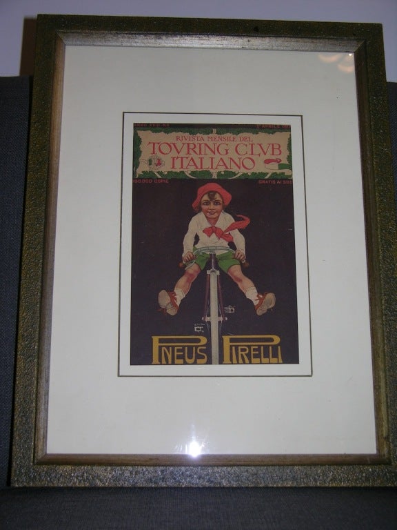 Front page, dated April 1st 1917, in colors, of the monthly Italian magazine Touring Club Italiano showing a child playing on a bike as an advertisement for tires by Pirelli, in a textured handcrafted wooden frame.