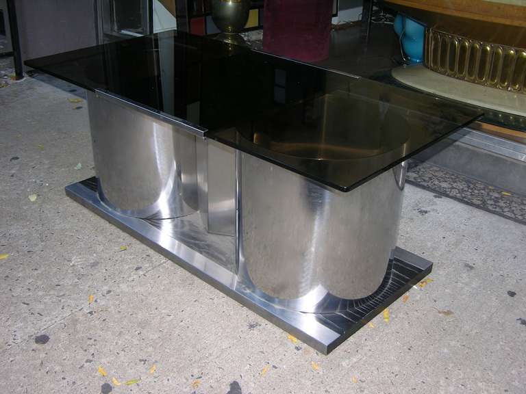 An elegant coffee table/bar with a high-quality tempered smoked glass top that swivels to reveal a lacquered interior inside two chrome cylinders. The interior can be used as a dry bar, great for cocktail hour, and it functions as storage. The