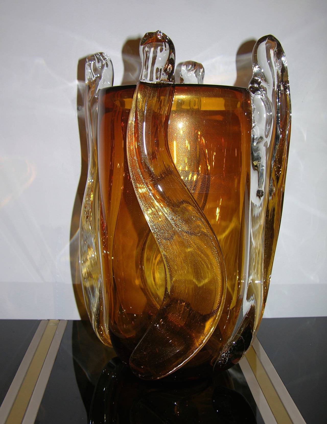 Extremely elegant and sexy 1970s vase, in deep whiskey Murano glass worked in the paste with pure gold and sexily accented with a waving 3-D clear glass decoration freely applied to the body. Signed Pino Signoretto.