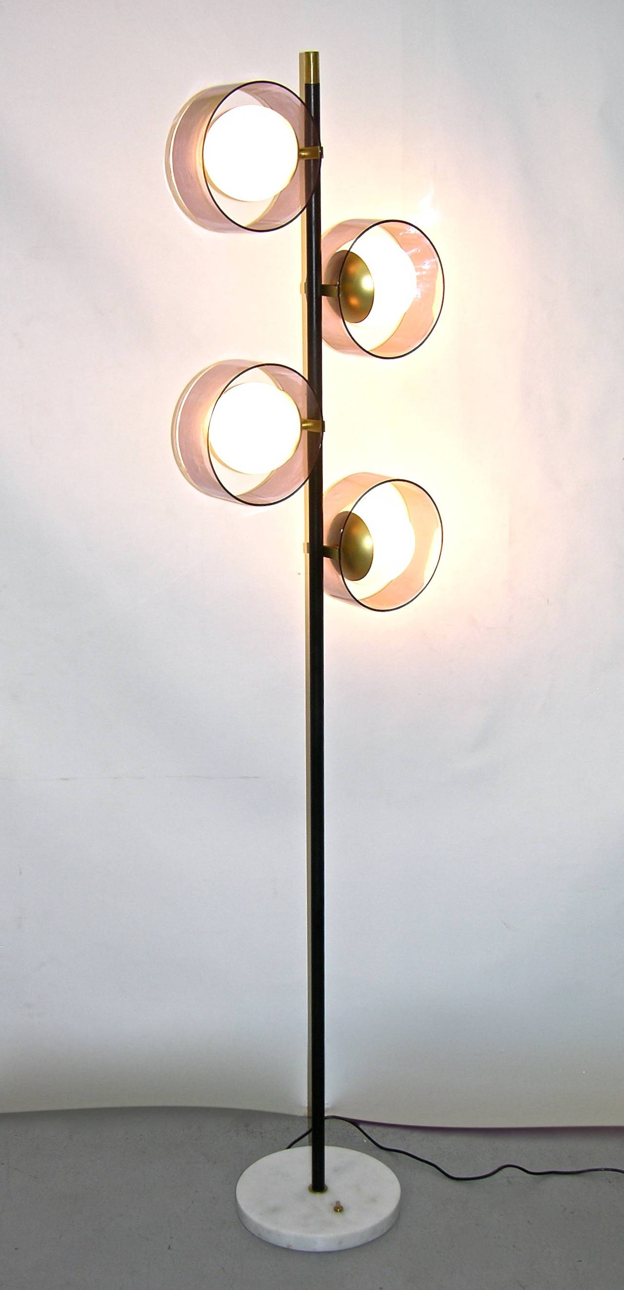 A very rare floor lamp signed Stilux in original condition, very decorative item with a statement design: the central metal pole, with brass finial and cold painted in black, supports four glazed white opaline glass globes, elegantly highlighted by
